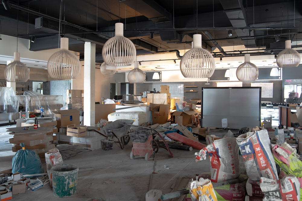 Innenraum eines Restaurants im Umbau mit Baustellenmaterial und dekorativen Lampen